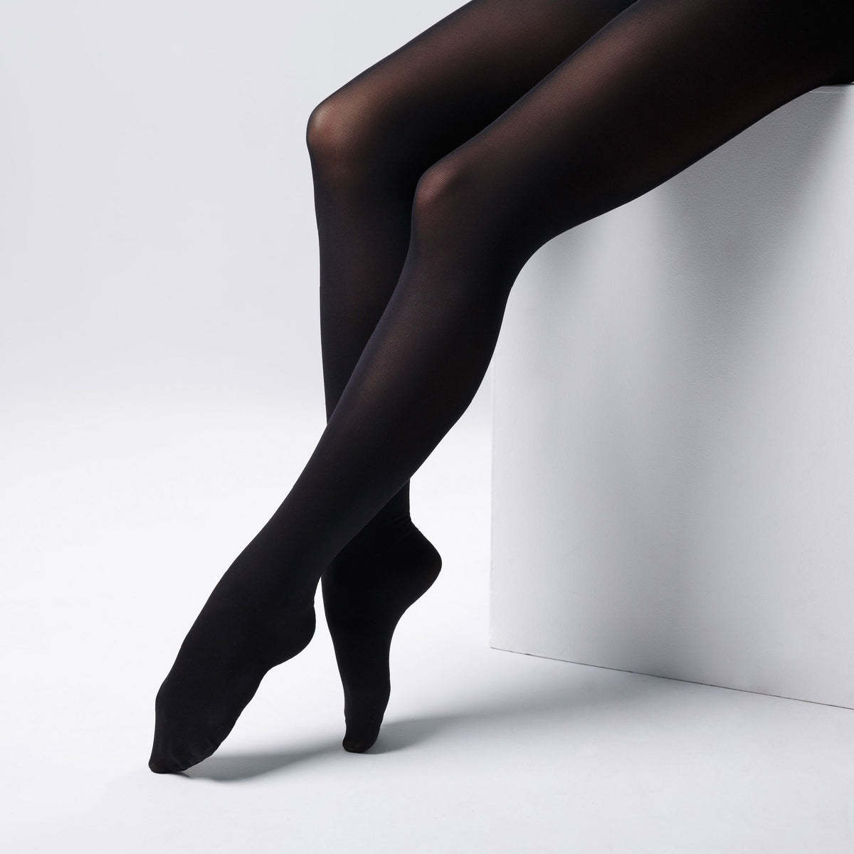 Image of woman's legs wearing opaque black tights by Fashion Accessory Company.  The image highlight the range of hosiery, pantyhose and tights from Fashion Accessory Company 